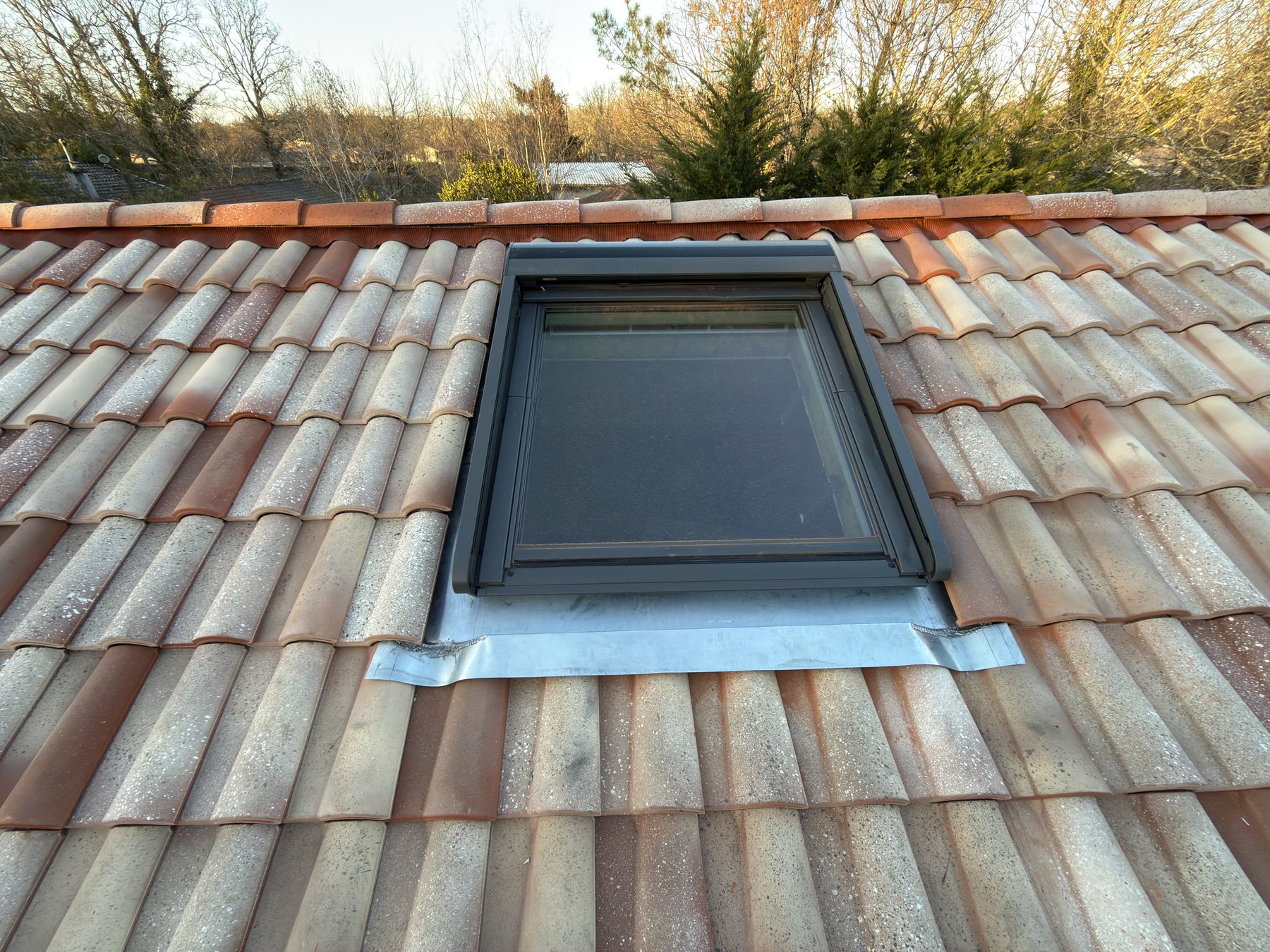 Installation d’une fenêtre de toit VELUX 134 par 140 cm avec entourage en zinc et volet roulant électrique