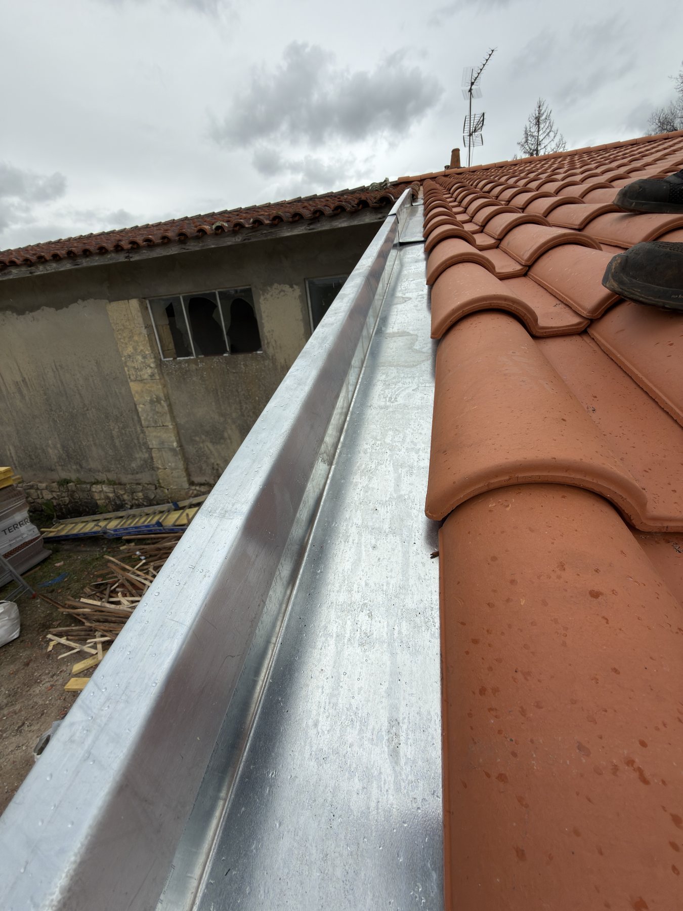 Couloir en zinc avec main courante réalisé sur une toiture en tuiles
